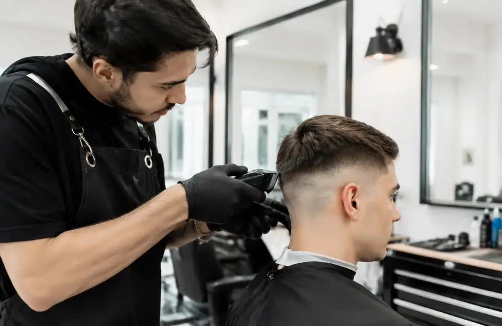 Barber trimming a client's beard in a barbershop
